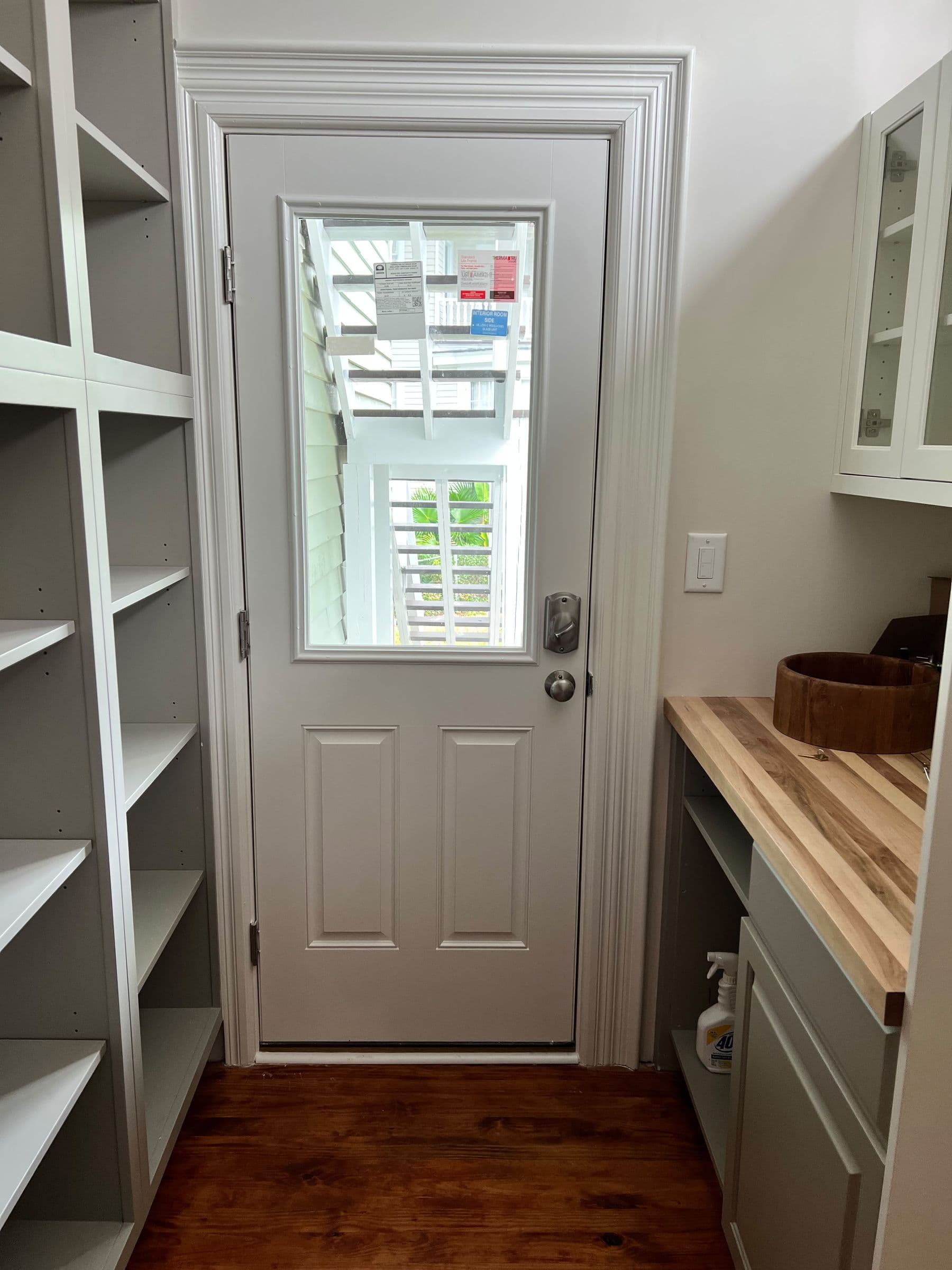 Built-in shelving beside a half-lite door on a hardwood floor
