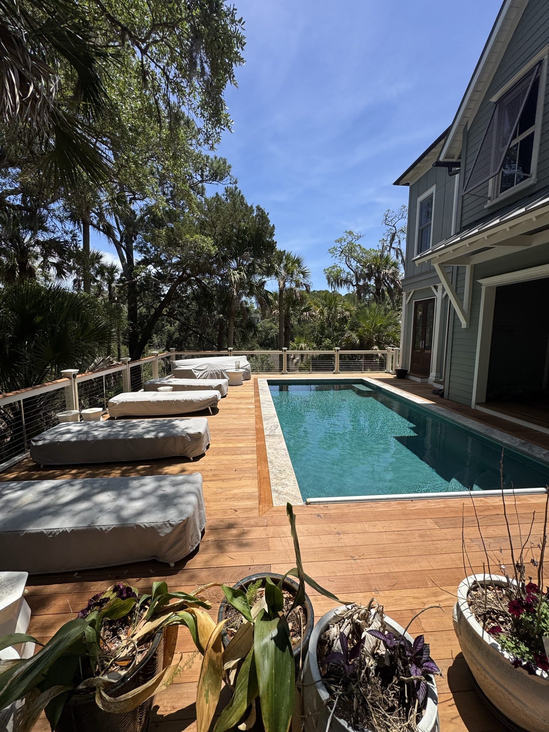Ipe deck and pool surround with lounge chairs beside the house
