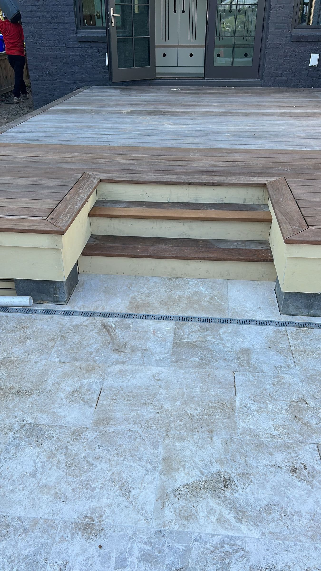 Deck with wide steps down to a stone pool surround