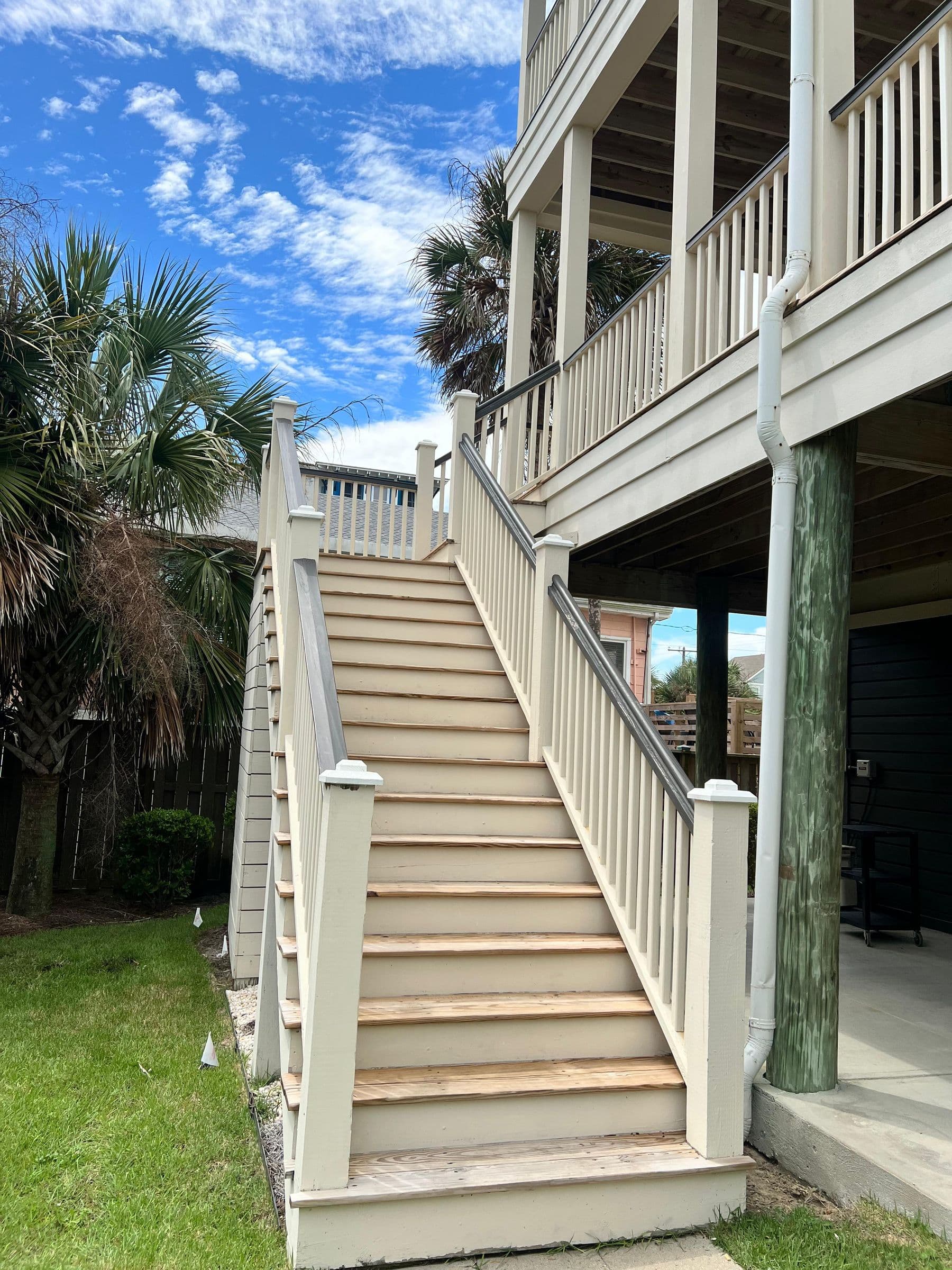 Long exterior stair with new treads and rails among palms