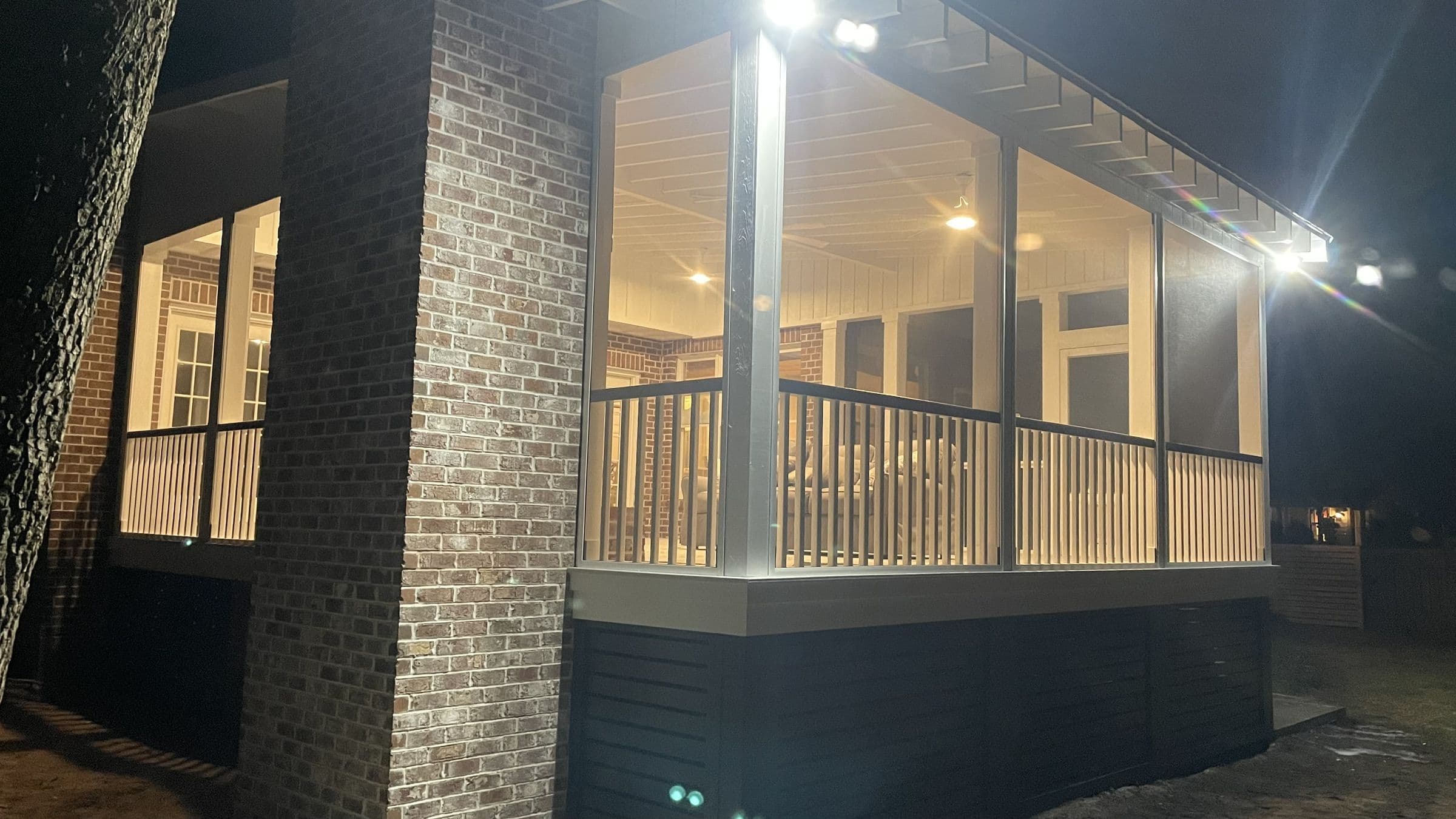 Screened porch addition with brick chimney at dusk