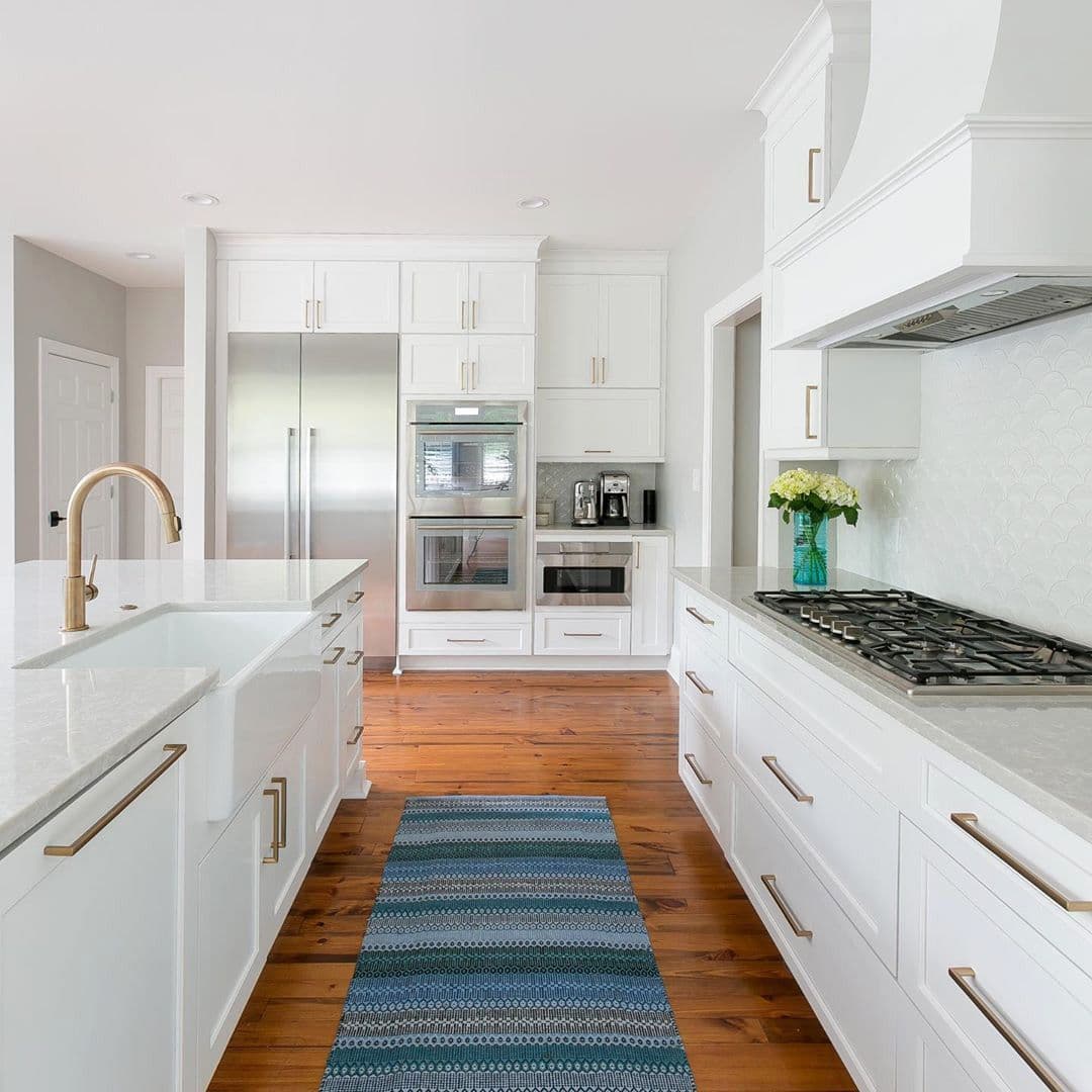 White kitchen with a farmhouse sink and heart pine floor